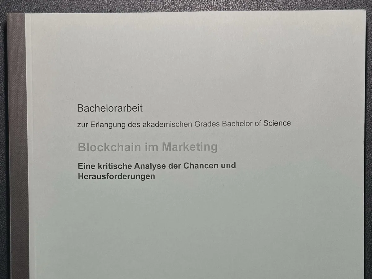 Titelblatt der gebundenen Bachelorarbeit „Blockchain im Marketing. Eine kritische Analyse der Chancen und Herausforderungen“, Ausschnitt mit Titel und dunklem Buchrücken.